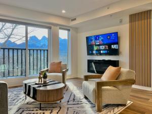 a living room with a fireplace and a tv at Luxury 2 Bedroom Mountain View Condo in Canmore