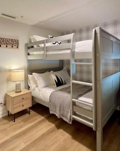 a bedroom with two bunk beds and a table at Luxury 2 Bedroom Mountain View Condo in Canmore +44 photos