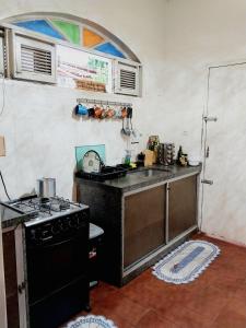 a small kitchen with a stove and a sink at Kariri Hostel in Crato