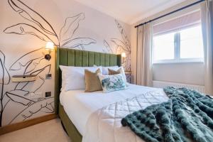 una camera da letto con un letto con testiera verde di Luxury Stay, City Walk, Pool Table & Air Hockey, Garden, Parking, Business & Families - Oakview a Colchester