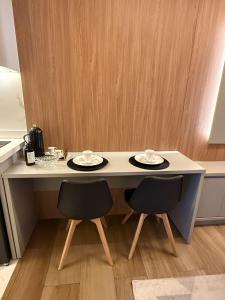 Studio Novo Moderno e Aconchegante - Centro في باراناغوا: طاولة بيضاء مع طبقين و كرسيين