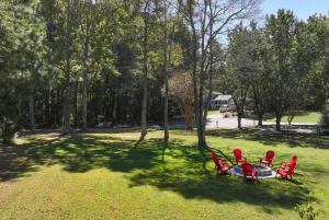 un grupo de sillas rojas y una mesa en un parque en Spacious 5BR Family Retreat Near Mall of GA Sleeps 13, en Buford