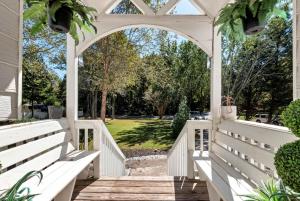 Un cenador blanco con bancos blancos en un patio. en Spacious 5BR Family Retreat Near Mall of GA Sleeps 13, en Buford 40 fotos más