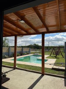 a patio with a pool and a wooden pergola at Abril, alquiler temporario in Piñero