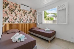 Ένα ή περισσότερα κρεβάτια σε δωμάτιο στο Villa Zanzibar - 4 chambers, piscine privée, plage à pied, idéale pour découvrir le nord Caraibe +55 φωτογραφίες