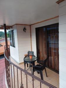 a balcony with a table and chairs on a house at Alto Cruz Executive Loft in Turrialba +3 photos