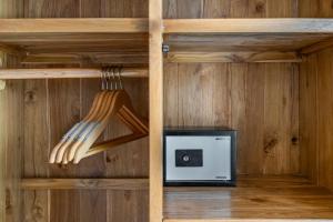 eine Küche mit Holzwänden, Mikrowelle und Küchenutensilien in der Unterkunft Boho Majipso Dreamy in Munggu