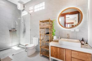 a bathroom with a sink toilet and a mirror at Boho Majipso Dreamy in Munggu