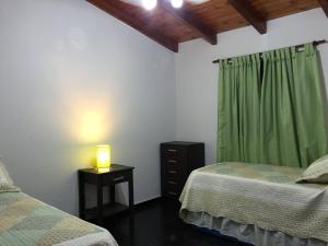 a bedroom with two beds and a lamp on a table at Tierras de Breena in Los Reartes