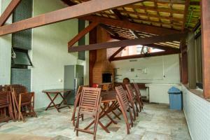 a dining room with a wooden table and chairs at Apartamento Riviera na Praça das Artes Módulo 6 in Riviera de São Lourenço
