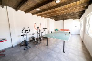 Palmeras Departamentos في سانتا تيريسيتا: صالة رياضية مع طاولة بينج بونغ ودراجات ممارسة الرياضة