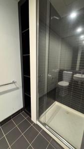 a glass shower in a bathroom with a toilet at One Bedroom Penthouse Apartment in the heart of Box Hill in Box Hill
