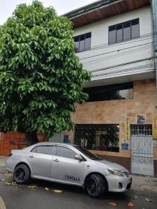 a white car parked in front of a building at Hotel Perezoso in Iquitos