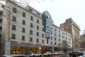 a large building on a city street with parked cars at Hotel Europa, BW Signature Collection in Montréal