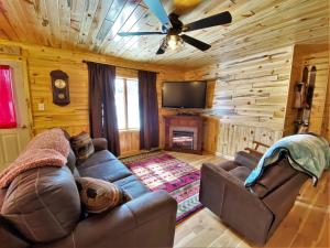 a living room with a couch and a ceiling fan at The Red Pine in Saint Ignace
