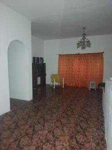 an empty room with a chandelier and a red curtain at Casa a 10 minutos de la playa y 15 del aeropuerto in Catia La Mar