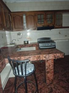 a kitchen with a counter with a chair in it at Casa a 10 minutos de la playa y 15 del aeropuerto in Catia La Mar