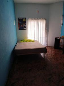 a bedroom with a bed in a room with a window at Casa a 10 minutos de la playa y 15 del aeropuerto in Catia La Mar