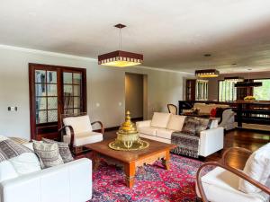 a living room with white furniture and a table at Teresopolis casa ampla em clube com piscina in Teresópolis