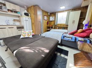 two beds in a small room with a kitchen at Casa de 1 quarto a cinco minutos da praia in Florianópolis +8 photos