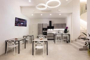 a dining room with tables and chairs and a kitchen at B&B IL MORO Boutique Rooms in Siena
