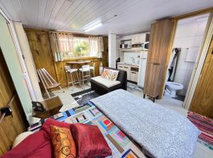 a small bedroom with a bed and a kitchen at Casa de 1 quarto a cinco minutos da praia in Florianópolis