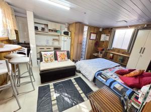 a bedroom with a bed and a table and a kitchen at Casa de 1 quarto a cinco minutos da praia in Florianópolis