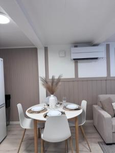 a dining room with a white table and chairs at Kirkevegen apartment in Brumunddalen