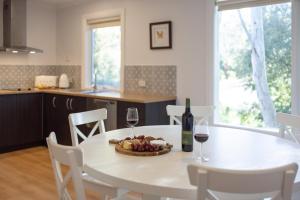 克莱尔Donnybrook Cottages - Donnybrook的一张白色的桌子上放着一碗水果和两杯酒