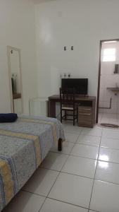 Un dormitorio con una cama, un escritorio y una silla. en Hotel Paraiso do Sol de Itarema, en Itarema