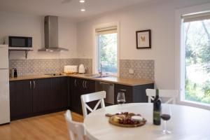 克莱尔Donnybrook Cottages - Donnybrook的厨房里有一张桌子，桌子上放着一碗水果 更多31张照片