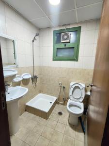 Paradise Living في فيصل آباد: حمام مع مرحاض ومغسلة وحوض استحمام