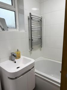 ein weißes Badezimmer mit Waschbecken und Dusche in der Unterkunft Wigan 2-Bedroom Modern house - Cozy & Relaxing Stay in Bickershaw