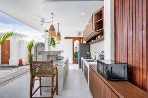 eine Küche mit Theke und TV in der Unterkunft Boho Majipso Dreamy in Munggu