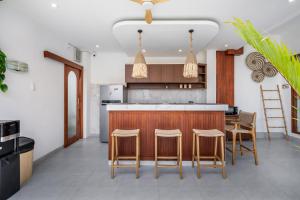 a kitchen with a bar with chairs and a counter at Boho Majipso Dreamy in Munggu