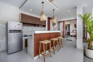 a kitchen with a counter and stools in a room at Boho Majipso Dreamy in Munggu +64 photos