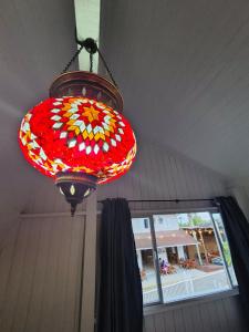 lampadario a braccio rosso e bianco appeso a un soffitto di Cabana Amarela Guarda do Embaú a Palhoça