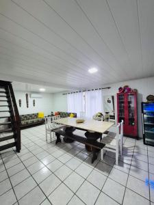 un soggiorno con tavolo e sedie in legno di Cabana Amarela Guarda do Embaú a Palhoça