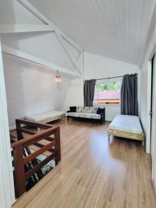 un soggiorno con due letti e un divano di Cabana Amarela Guarda do Embaú a Palhoça