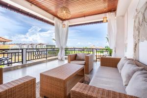 ein Wohnzimmer mit einer Couch und Stühlen auf einem Balkon in der Unterkunft Boho Majipso Dreamy in Munggu