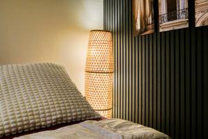 a lamp sitting next to a bed in a room at Paris-Eiffel, bienvenue -terrasse -Netflix in Pantin