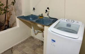 a bathroom with a sink and a washing machine at Aconchegante Casa na vila de pescadores in Baixio +8 photos