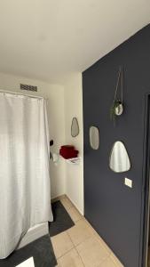 a bathroom with a white shower curtain and mirrors at Nawalie in Pointe-à-Pitre