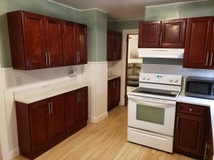 a kitchen with wooden cabinets and white appliances at Grand Central - Pet friendly 3 BR 2 Bath in Johnson City