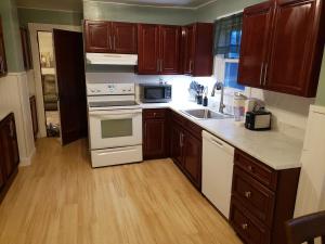 a kitchen with wooden cabinets and white appliances at Grand Central - Pet friendly 3 BR 2 Bath in Johnson City +13 photos
