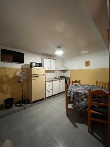 una cucina con un tavolo e una cucina con un frigorifero di Piltri2 monoambiente a El Bolsón