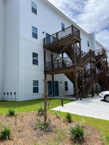 ein Gebäude mit einer Holztreppe neben einem Gebäude in der Unterkunft 2BR Townhome in Valdosta Private Convenient Spacious in Valdosta