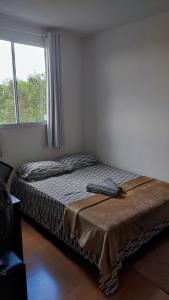 een bed in een kamer met een groot raam bij Apartamento Santa Isabel in Cuiabá