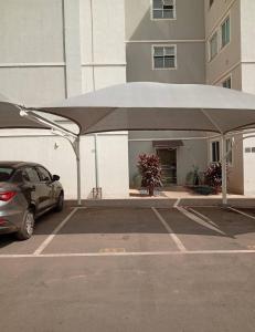 een auto geparkeerd op een parkeerplaats met een grote paraplu bij Apartamento Santa Isabel in Cuiabá