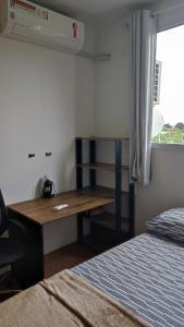 een bureau in een kamer met een bed en een raam bij Apartamento Santa Isabel in Cuiabá +15 foto's